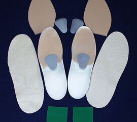 Darstellung der Komponenten einer Weichschaumeinlage. Verwendet werden verschiedene stützende und bettende Elemente unterschiedlicher Härte.